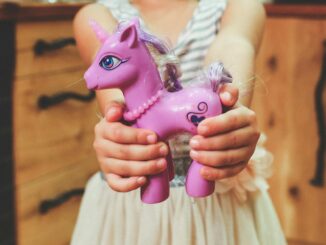 child holding unicorn toy