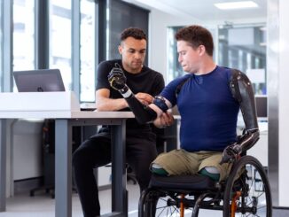 engineer fitting prosthetic arm